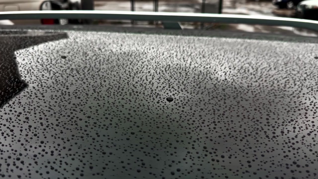 Hydrofobowe krople wody perleniące się na zabezpieczonym dachu samochodu po deszczu