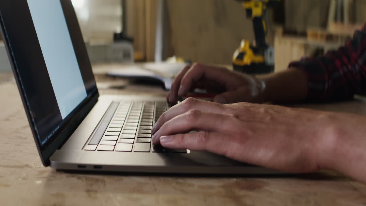 Snedker bruger bærbar computer på et værksted
