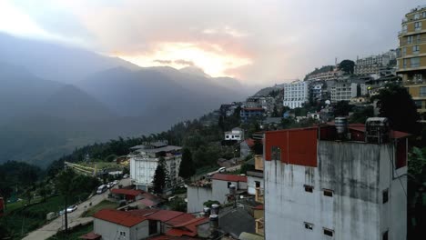 Sobrevuelo-De-La-Ciudad-Montañosa-De-Sapa,-Vietnam-Durante-La-Puesta-De-Sol-En-Las-Nubes