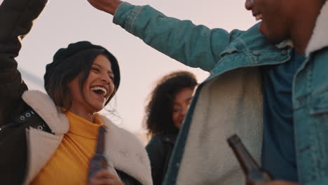 group of multiracial friends hanging out young mixed race woman dancing enjoying rooftop party at sunset drinking alcohol having fun on weekend celebration