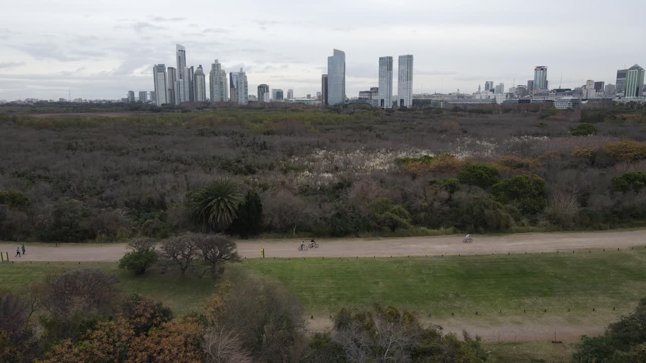 도시 외곽을 따라 비포장 도로에서 자전거를 타는 시민들의 공중 측면 보기