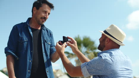 Medium-shot-of-homosexual-man-proposing-to-lover-on-summer-day