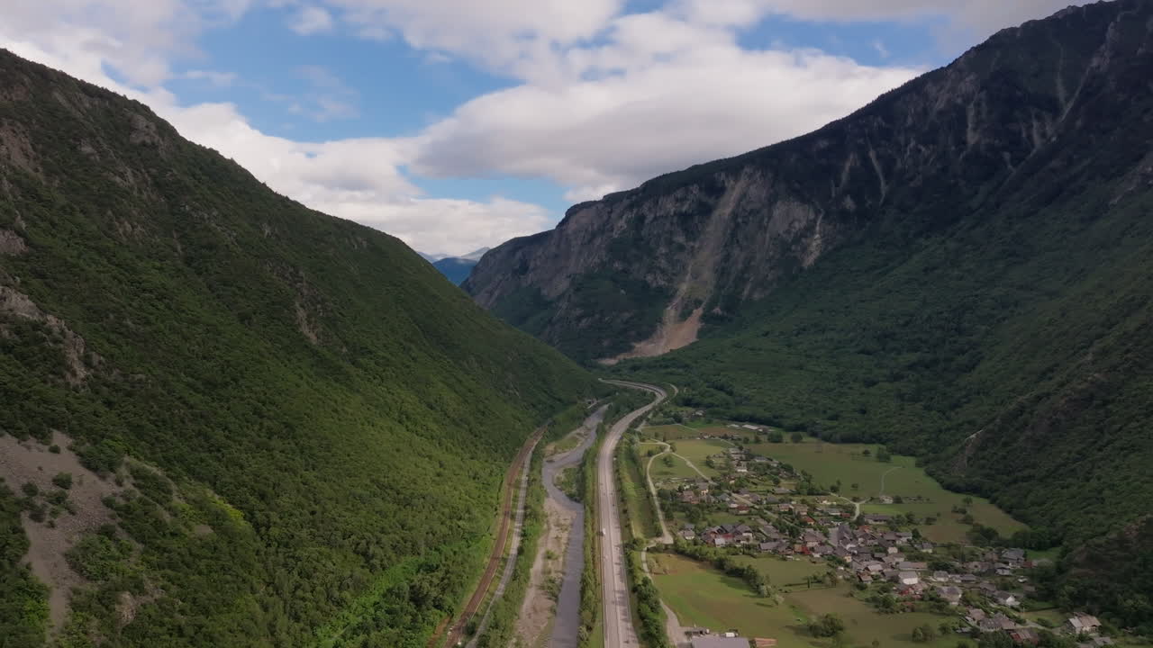 vista aérea de un valle de montaña con una carretera y un río