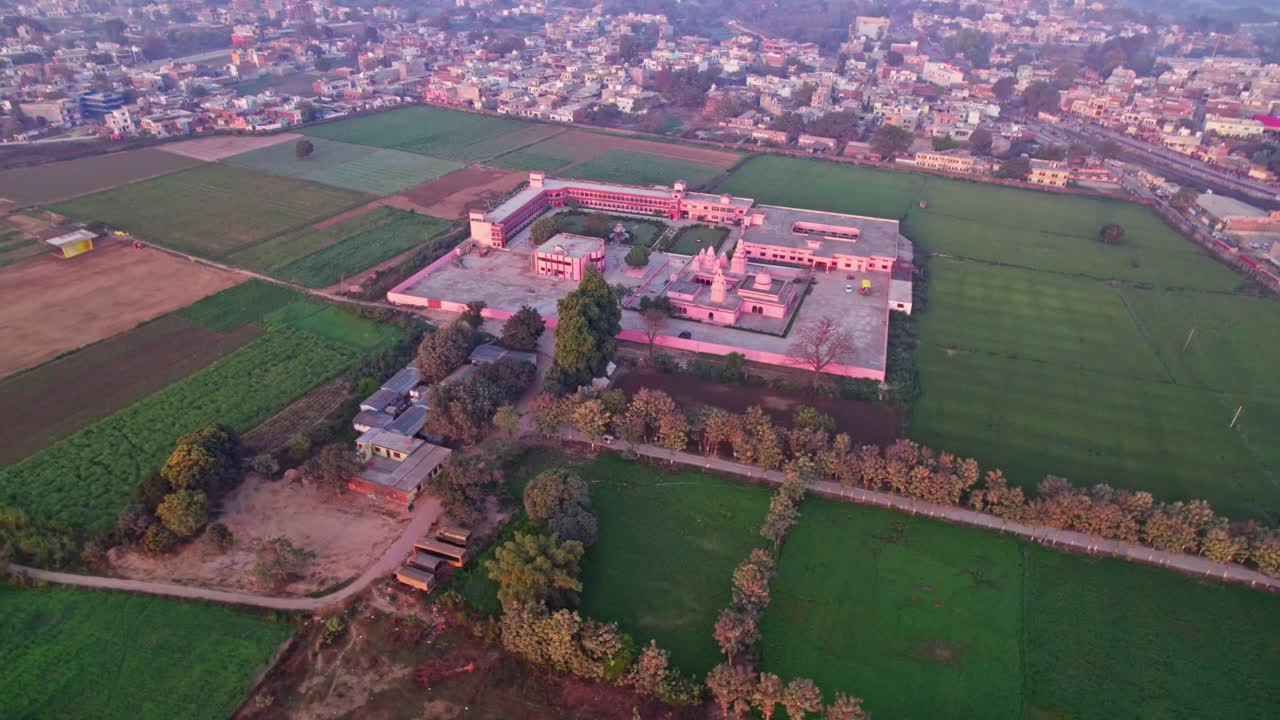 SHRI UDASIN SANGAT RISHI ASHRAM with crop field lands and residential buildings, at Ranopali Village, Ayodhya, Uttar Pradesh, india. day time, push in, drone shot, 4k.