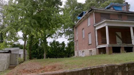 abandoned home in vine city neighborhood in atlanta, georgia with drone video close up pulling back