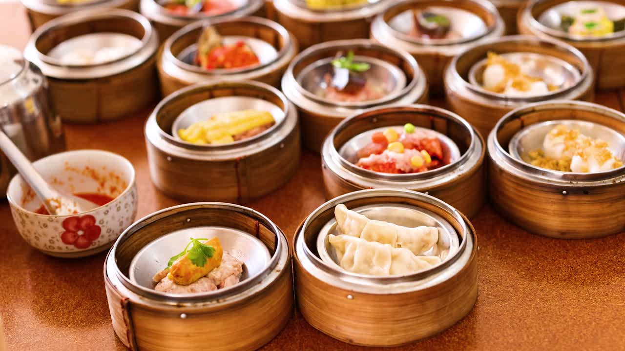 A variety of steamed dim sum dishes in bamboo baskets, captured in warm lighting at a Phuket restaurant