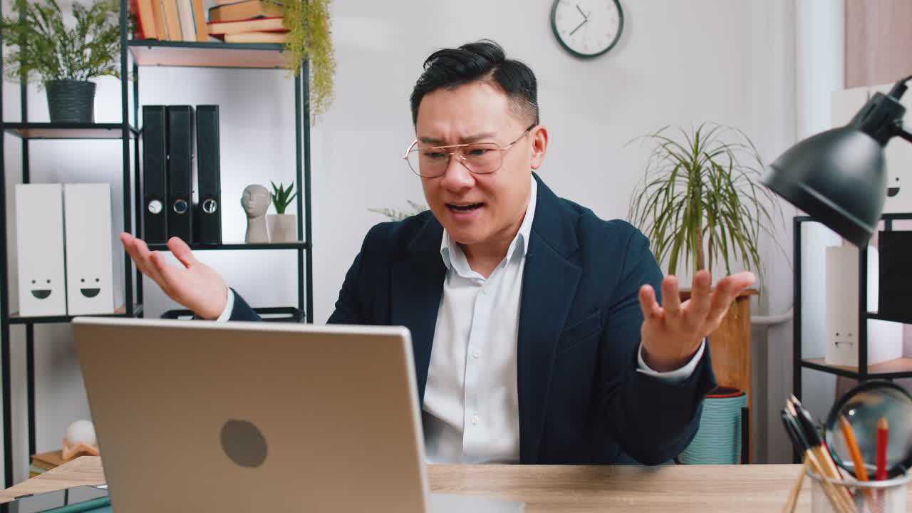 Angry businessman ceo making laptop call conversation at home office quarrel conflict negotiation