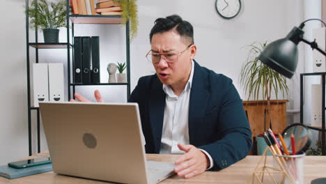 man working on laptop in home office during a video call