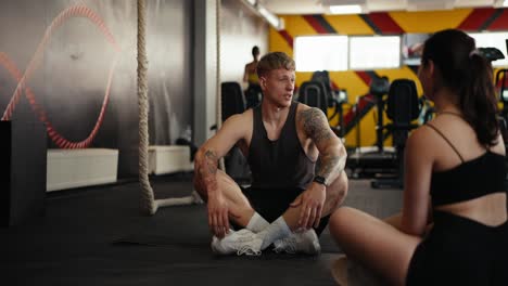 hombre y mujer hablando en el gimnasio.