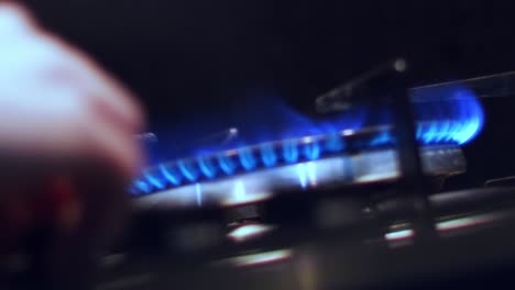 slow motion, person's hand turning off stovetop fire