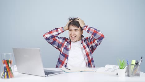 man looks at laptop and rejoices.