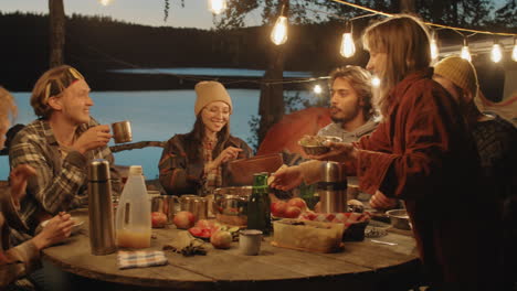 amigos cenando juntos en el campamento por la noche