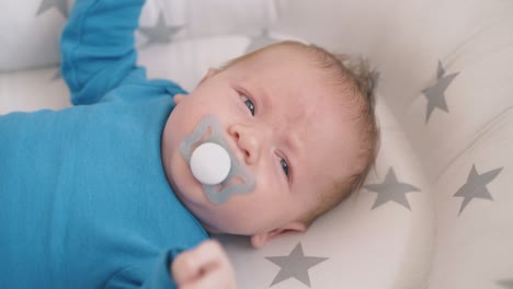 small child with pacifier awakes from nightmare in cocoon