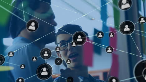 Animation-of-network-of-connections-with-icons-over-diverse-people-in-office
