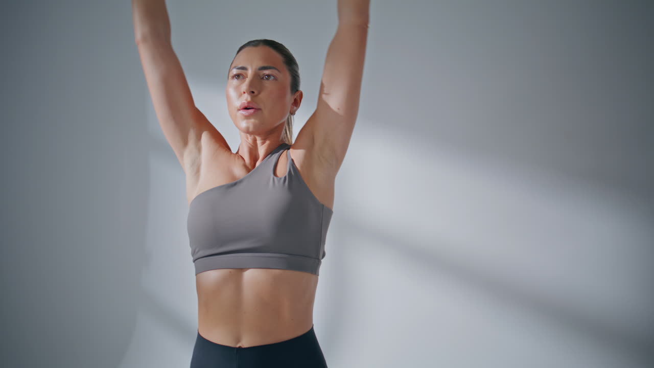 Muscular sportswoman holding dumbbells in fitness center. Woman biceps workout