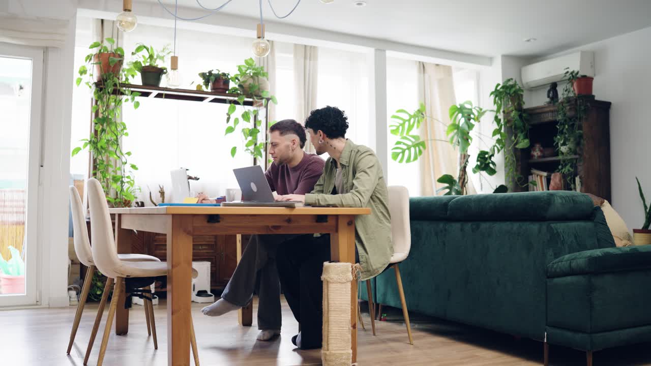 Two Young Men Collaborating on Laptop at Home