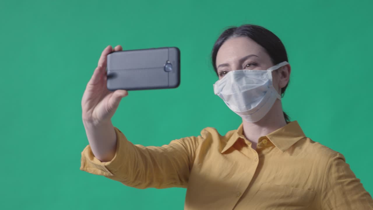 수술 마스크를 쓰고 셀카를 찍는 젊은 여성