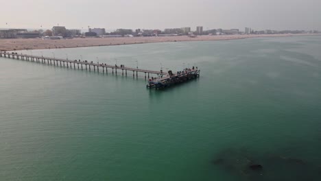 drone shot of a dock bridge, taken on a black sea beach