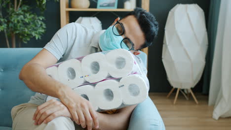 man sleeping on a pile of toilet paper during a pandemic