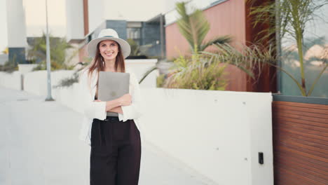 mujer caminando con una computadora portátil al aire libre