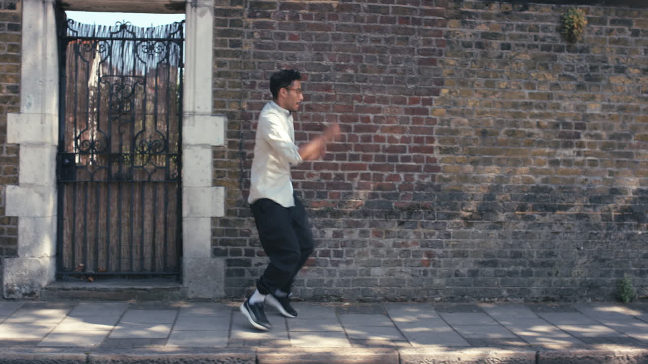 Contemporary funky mixed race man street dancer dancing freestyle in the city