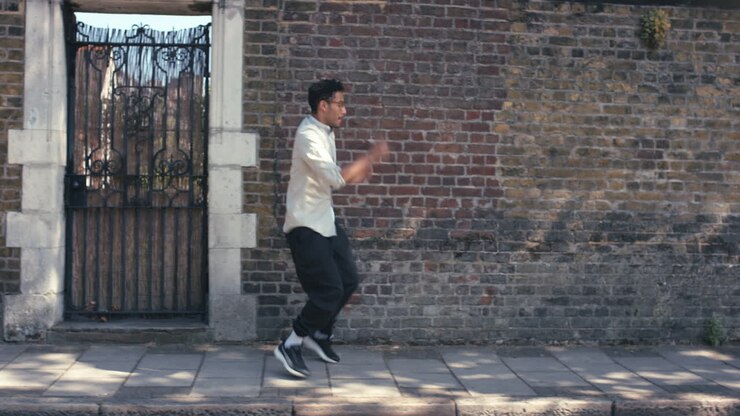 Uomo di etnia mista ballerino di strada contemporaneo e funky che balla freestyle in città.