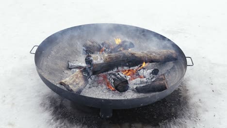 High-angle-close-up-of-outdoor-garden-fire-pit-bowl,-burning-wood-for-barbecue