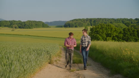 two farmers discuss business and walk along dirt road