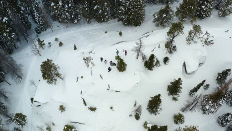 Aerial-orbiting-shot-of-a-group-of-people-on-a-snowy-mountain