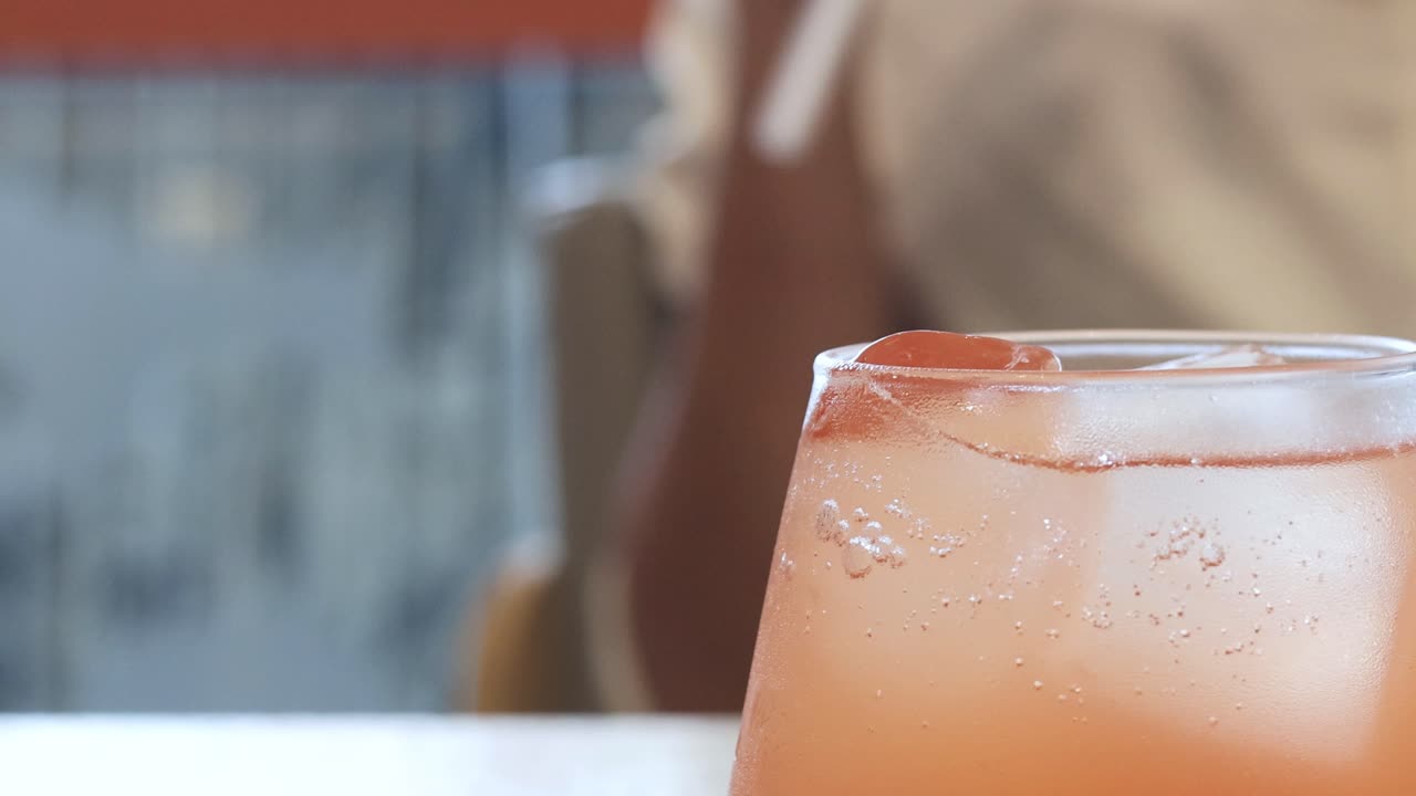 사람 은 상쾌 한 분홍색 음료 를 즐긴다