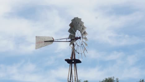 Wind-pump-vane-turning-in-the-wind-against-sky-background