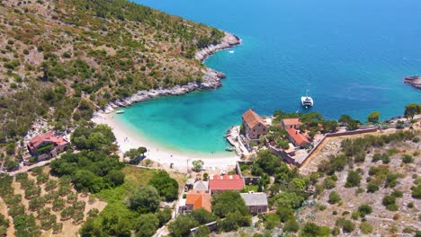 Panorama-of-a-coastal-town-with-many-houses-with-red-roofs,-surrounded-by-the-sea-and-mountains