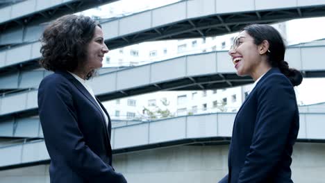 smiling businesswomen shaking hands