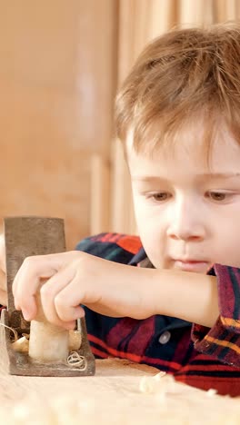 young boy learning to plane wood
