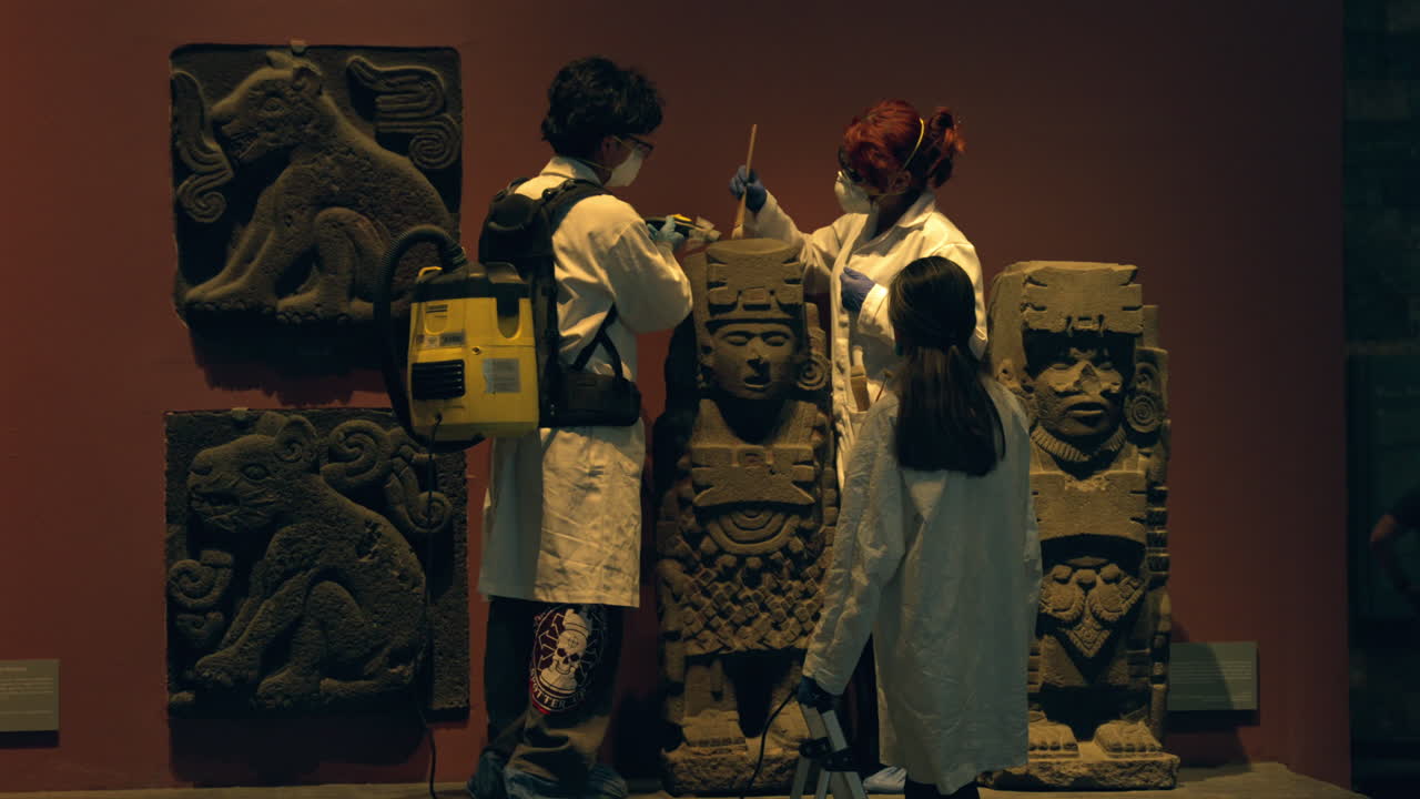 Curators brushing and cleaning an ancient statue in the museum