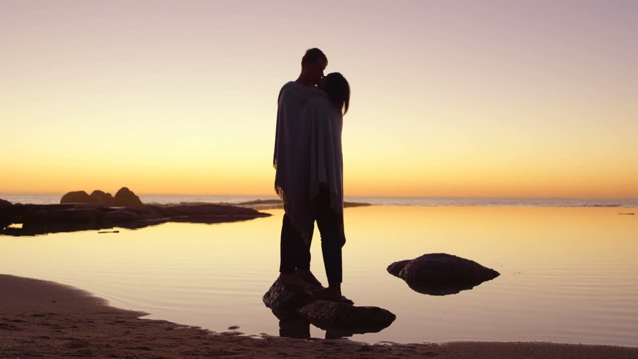 로맨틱 한 커플 이 바위 해안 에서 서로 키스 하고 있다