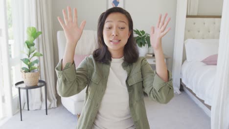 Mujer-Asiática-Feliz-Teniendo-Videollamada-En-El-Dormitorio,-En-Cámara-Lenta