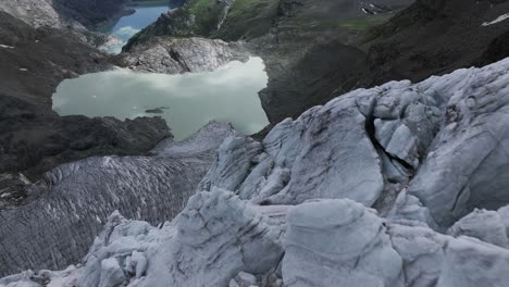 drone volando a baja altitud sobre la superficie del glaciar fellaria con la laguna en el fondo, valmalenco en italia