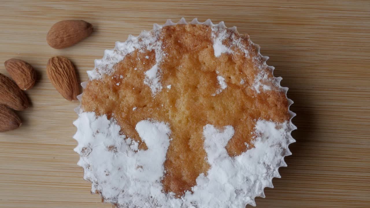 Tarta de Santiago cake with almonds on wooden board close up
