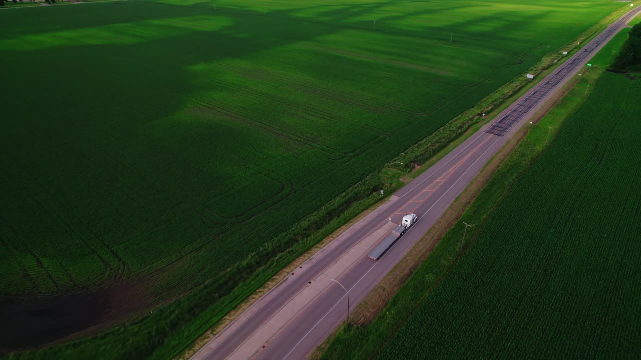 Aerial View of Truck Driving on a Highway Through Cornfields