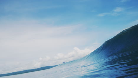 Clear-blue-ocean-water-as-wave-rises-and-barrels-against-blue-sky