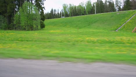 vista a través de la ventana lateral del automóvil en movimiento en la carretera. autopista a lo largo del bosque verde y los árboles en verano. turismo y viajes, concepto de viaje de viaje. hermosa naturaleza y paisaje. automóvil acelerando en el camino.
