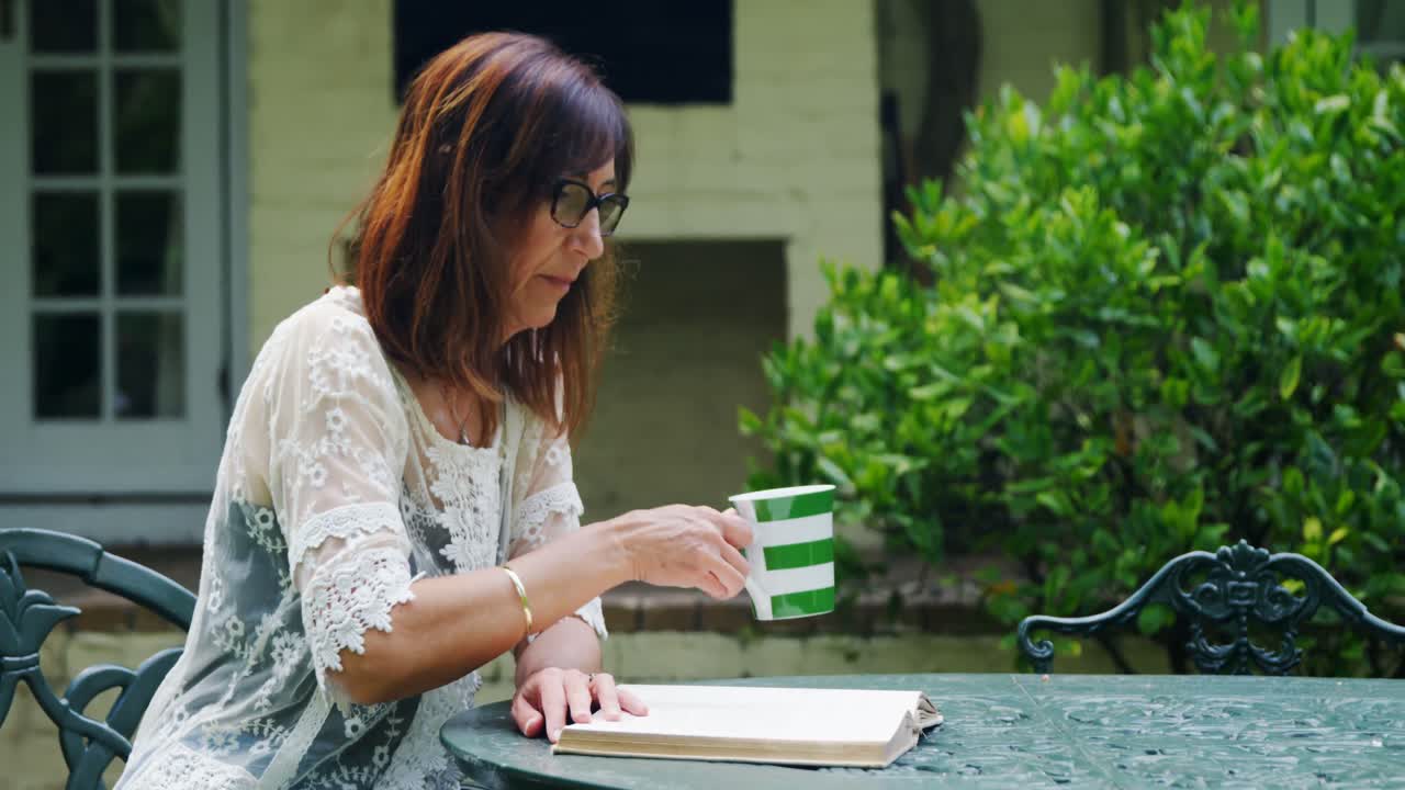 책 4k를 읽는 동안 커피를 마시는 성숙한 여성