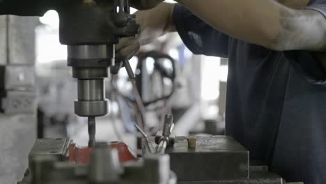 workers are working drilling machine, drilling thick steel in the industrial factory. slow motion