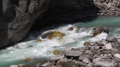 巨大的岩石底部的河流中的蓝色灰色冰川水