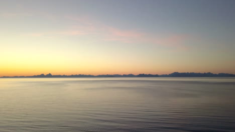 aerial shot of beautiful sunset on crystal white beach in the north of norway. shot at bøsanden in steigen, with a view of lofoten.