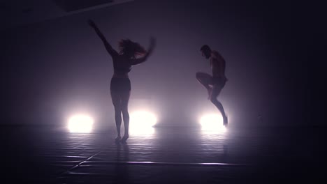 skillful dancers practicing modern dance in studio on the floor. studio of modern dance.