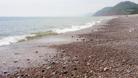 Kleine-Wellen-Rollen-An-Einem-Warmen,-Diesigen-Tag-Auf-Den-Kiesstrand-Von-Branscombe-In-Devon-An-Der-Englischen-Kanalküste