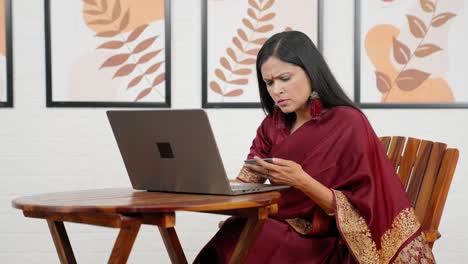 confused indian woman using credit card