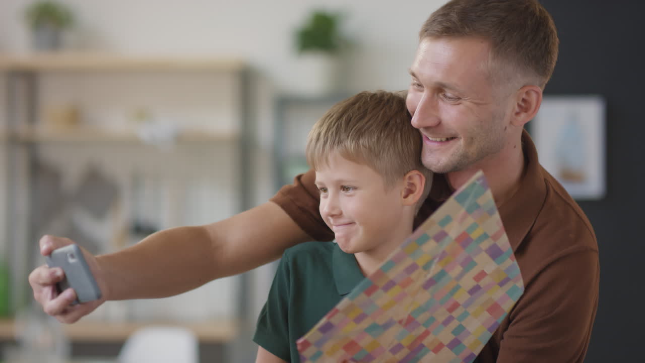 padre e hijo tomando una selfie con un regalo